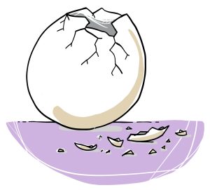 Un œuf à la coquille fissurée en haut. Des fragments de la coquille sont éparpillés à côté.